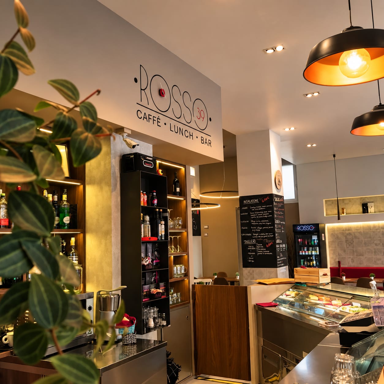 Interno del Bar Rosso 39, bancone con luci calde e piante