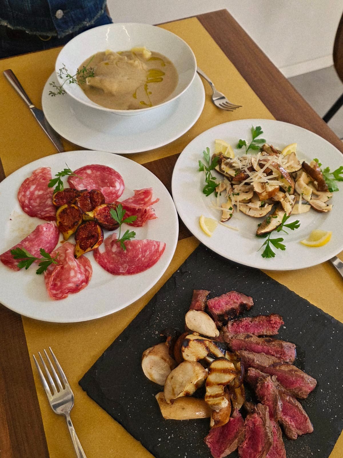 Tavola con salumi e fichi, funghi, vellutata e tagliata