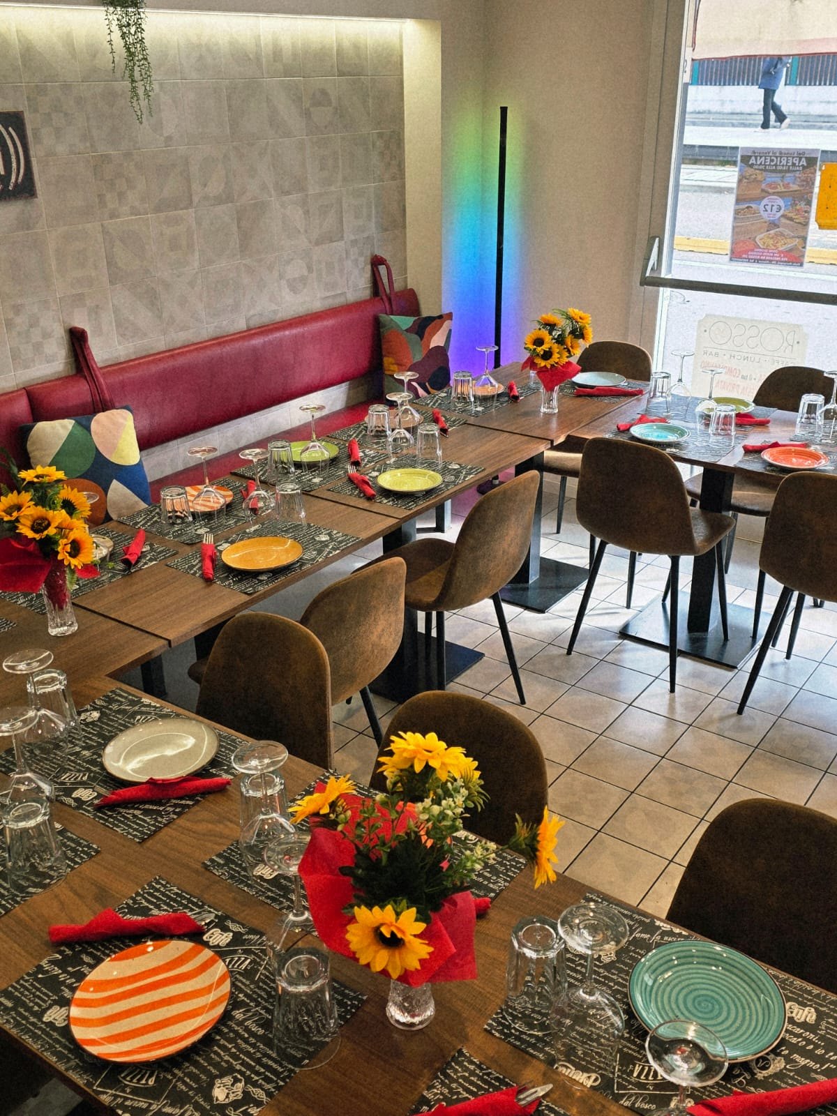 Sala apparecchiata con girasoli e piatti colorati